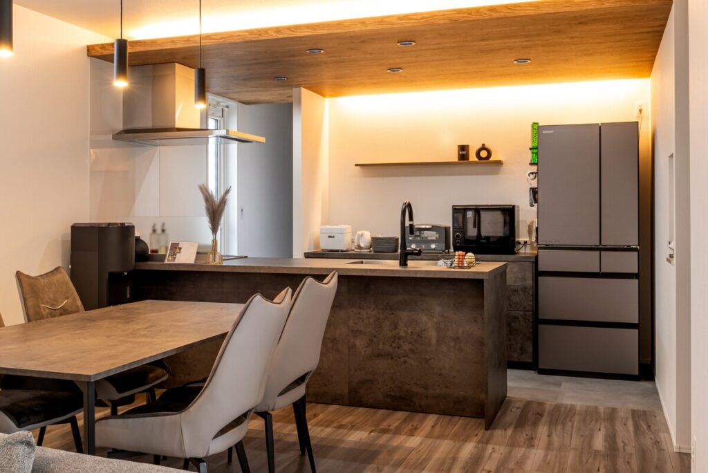 間接照明と木目天井が落ち着いた雰囲気を演出するダイニングキッチン