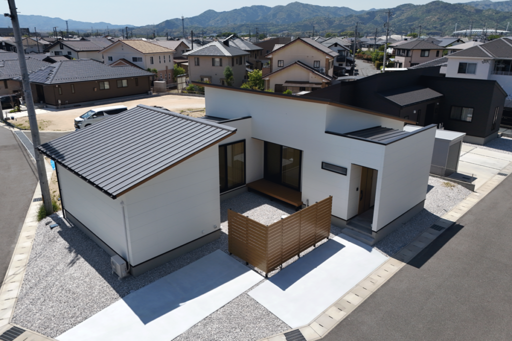 白い外壁と片流れ屋根が特徴的な、中庭のある平屋の家づくりの外観。