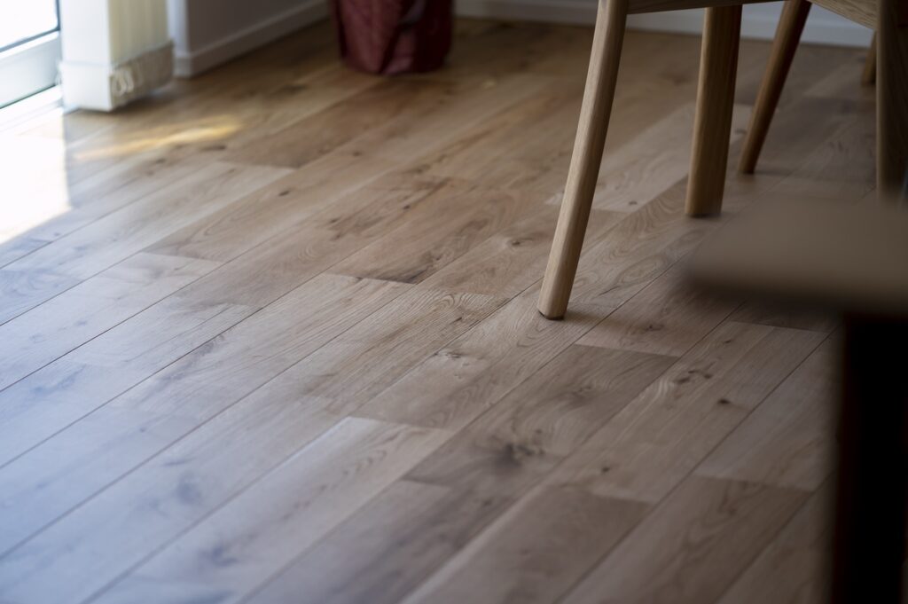 陽の光を反射する、表情豊かな節目のある無垢フローリングのテクスチャ