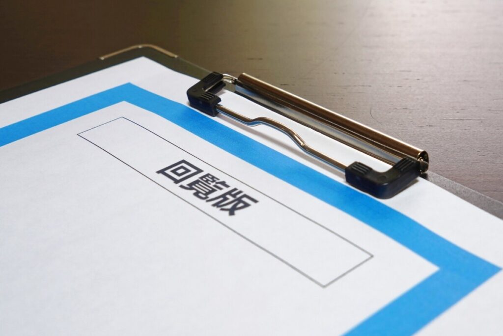 「回覧板」と記されたバインダー。分譲地内での住民同士の自治活動を象徴するイメージ。