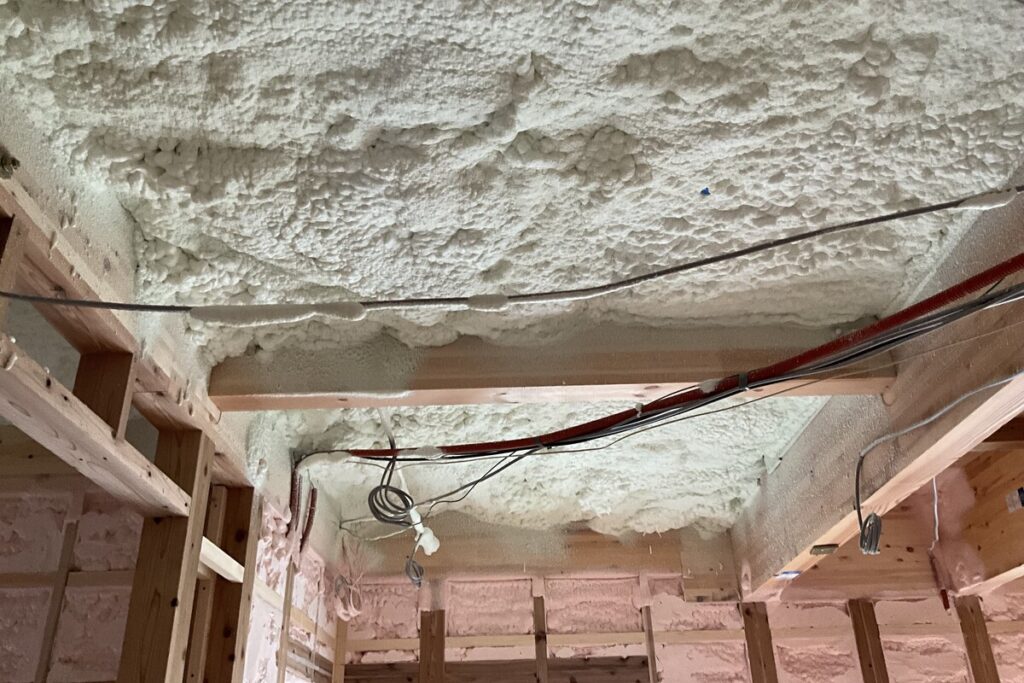 住宅の天井と壁に隙間なく吹き付けられた断熱材（発泡ウレタン）の施工様子
